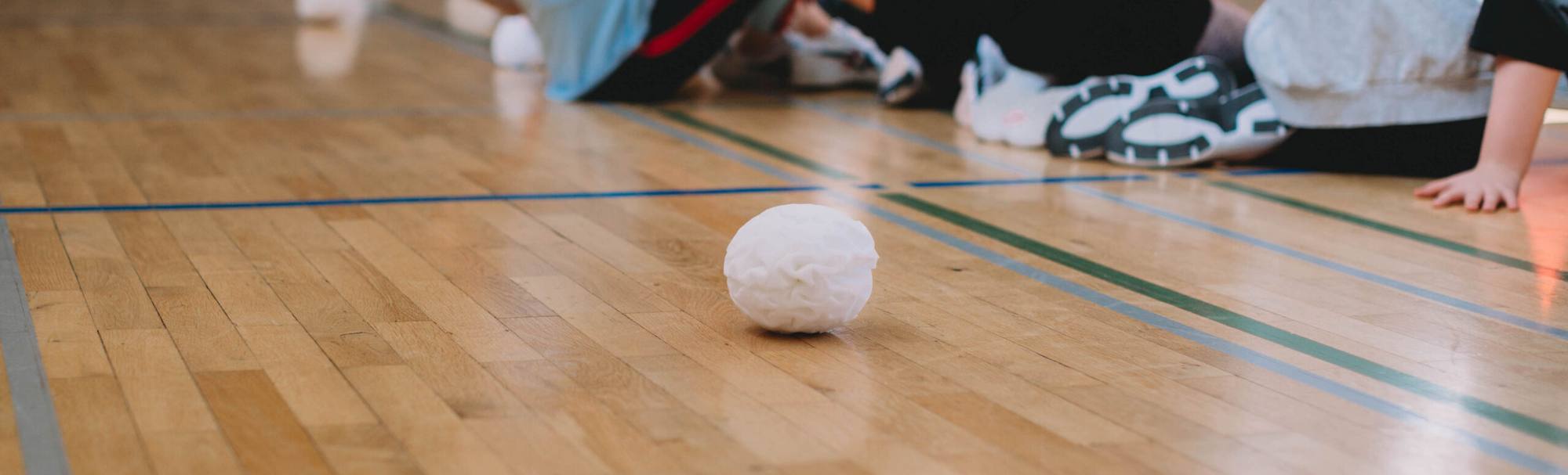 Una palla di neve di gommapiuma bianca sul pavimento della palestra